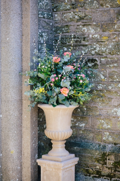 Urn filled with mixed foliage and splashes of colour