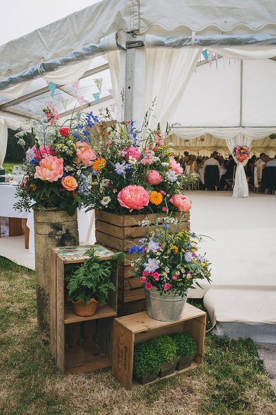 Crates and pots filled with flowers transform the entrance of this marquee